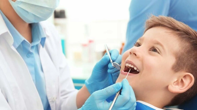 Friendly Pediatric Dentist Treating Smiling Child Patient